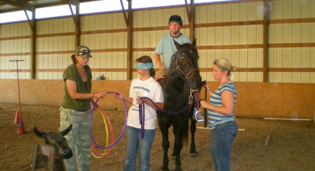 group of people in front of a horse while one person is riding